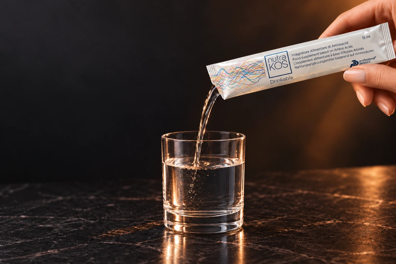 Liquid Nutrakos being poured from a sachet into a small glass of water